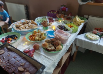 Auf einem Tisch stehen viele Teller, Schüsseln und Backblechen mit verschiedenen Obst, Gemüse und Gebackenem.