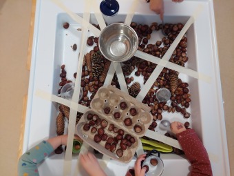 Kind experimentiert mit Kastanien