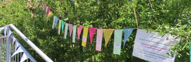 An einer bunten Wimpelkette hängen kleine Zettel mit Aussagen von Kindern, was sie Im Kindergarten schön finden. 