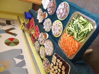 Ein Buffett mit verschiedenen Kuchensorten, Obstplatten und Gemüseplatten. 