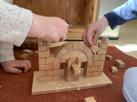 Kinder bauen an einer Montessori Holz - Brücke