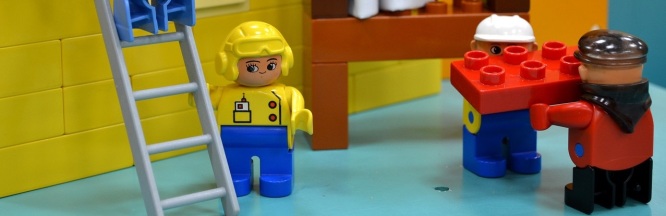 Legofiguren stehen auf einer Legobaustelle.