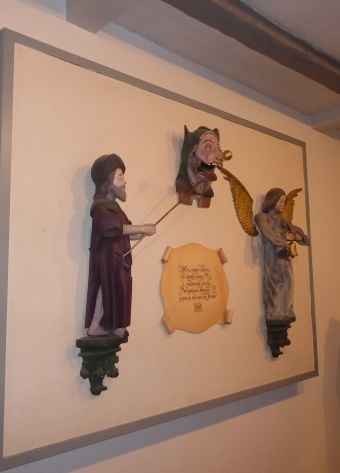 An einer Tafel hängen drei Figuren des Museums, eine schnappt nach einer Kugel