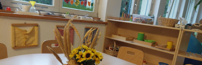 Ein Gruppentisch im Kindergarten mit herbstlichen Blumen